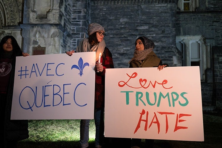 Mourners hold up Love Trumps Hate sign at vigil for victims of Quebec City mosque shooting