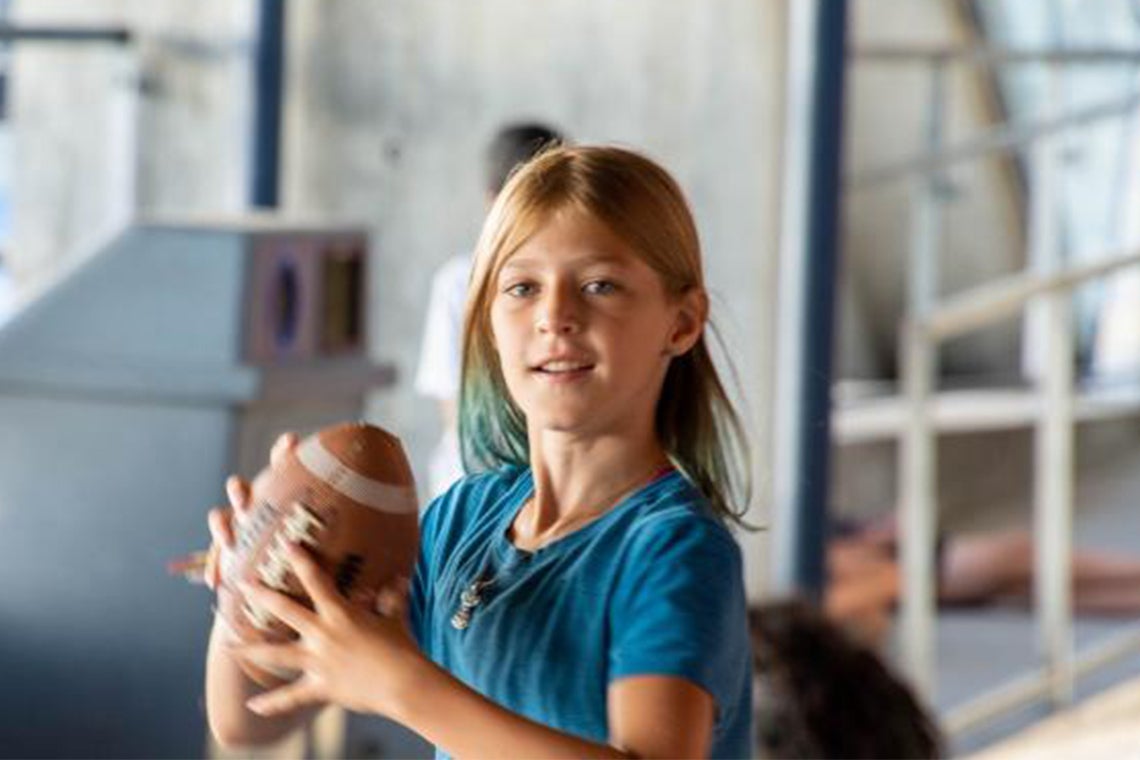 young girl catches a football