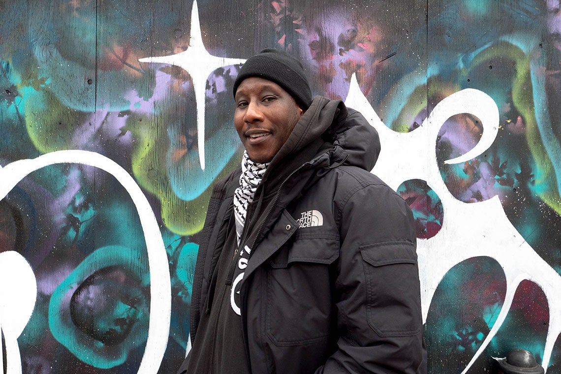 photo of Marcus Singleton standing in front of a graffitti wall