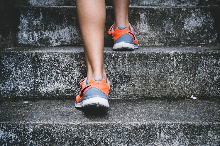 close up of woman's feet jogging up a flight of stairs