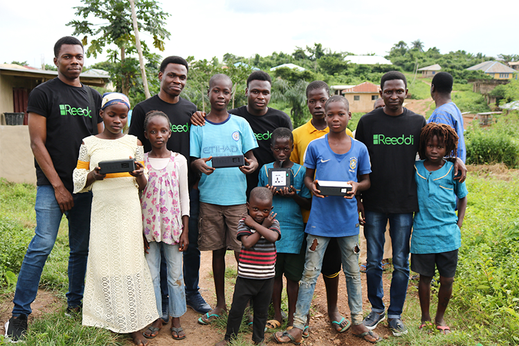 Olugbenga Olubanjo poses for a photo in Ayegun, Nigeria with members of his reedi team and local community members