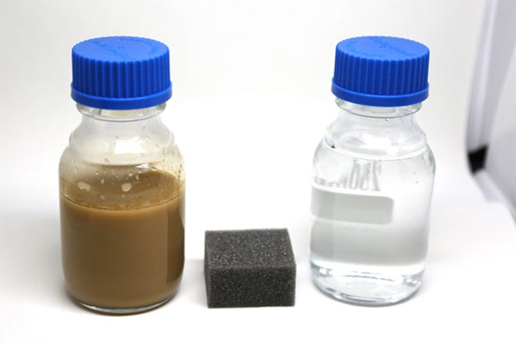 two small vials show what oil contaminated water looks like before and after the sponge is used. The before water is brown and opaque while the after is clear.