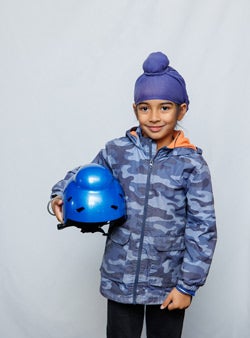 Child with patka holding the special helmet with the bump for the patka