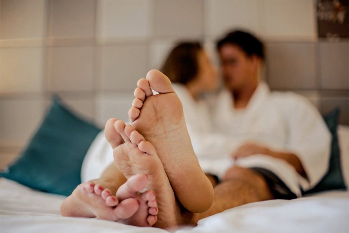 woman and a man speaking to each other in bed