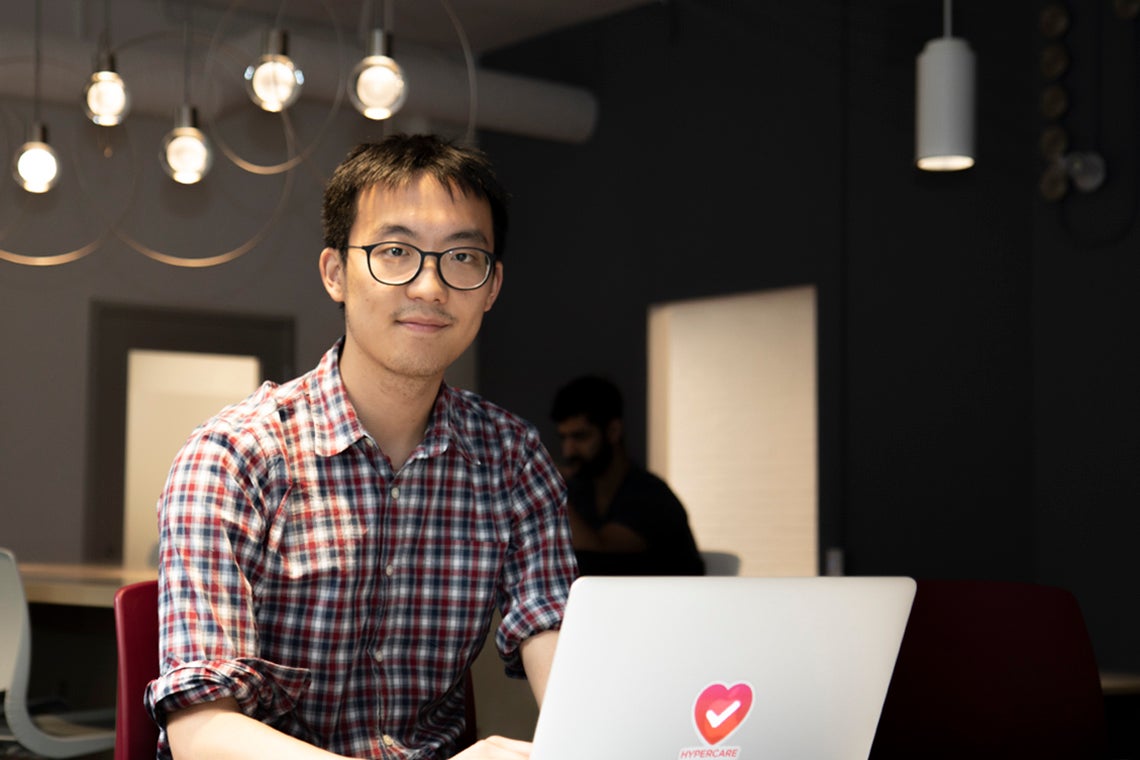 Albert Tai working on a laptop at On Ramp located at U of T