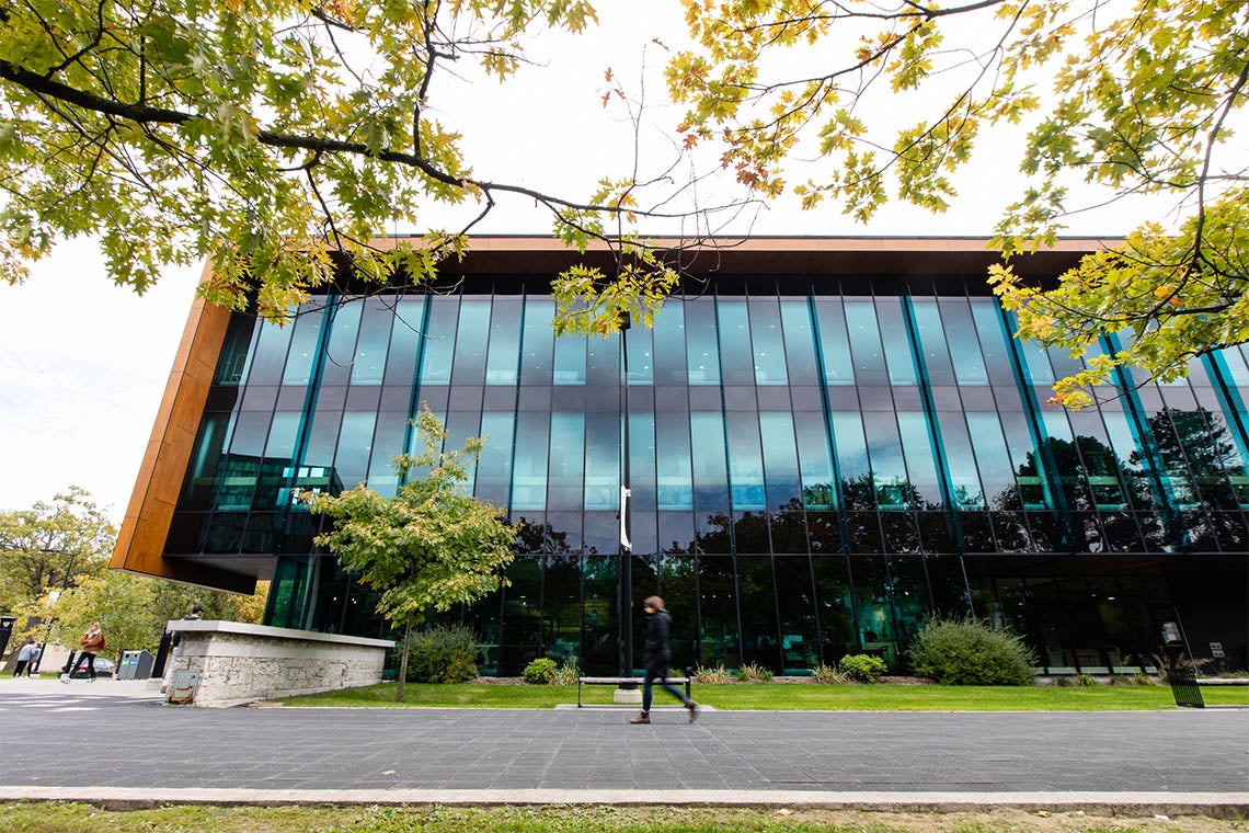 A student walks by a building on the U of T Mississauga campus