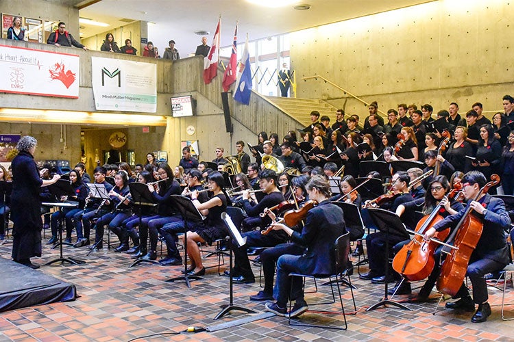 an orchestra plays on remembrance day at the meeting place at UTSC