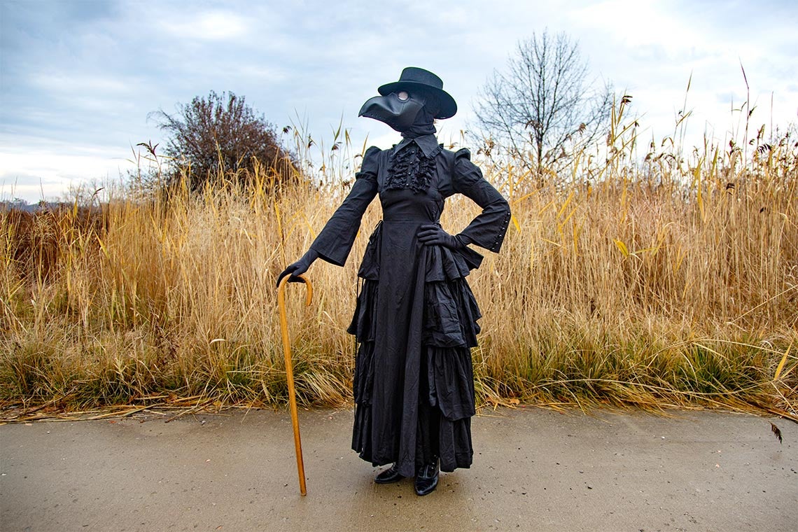 Madeleine Mant in costume as a plague doctor. The leather mask resembles the face of a black bird