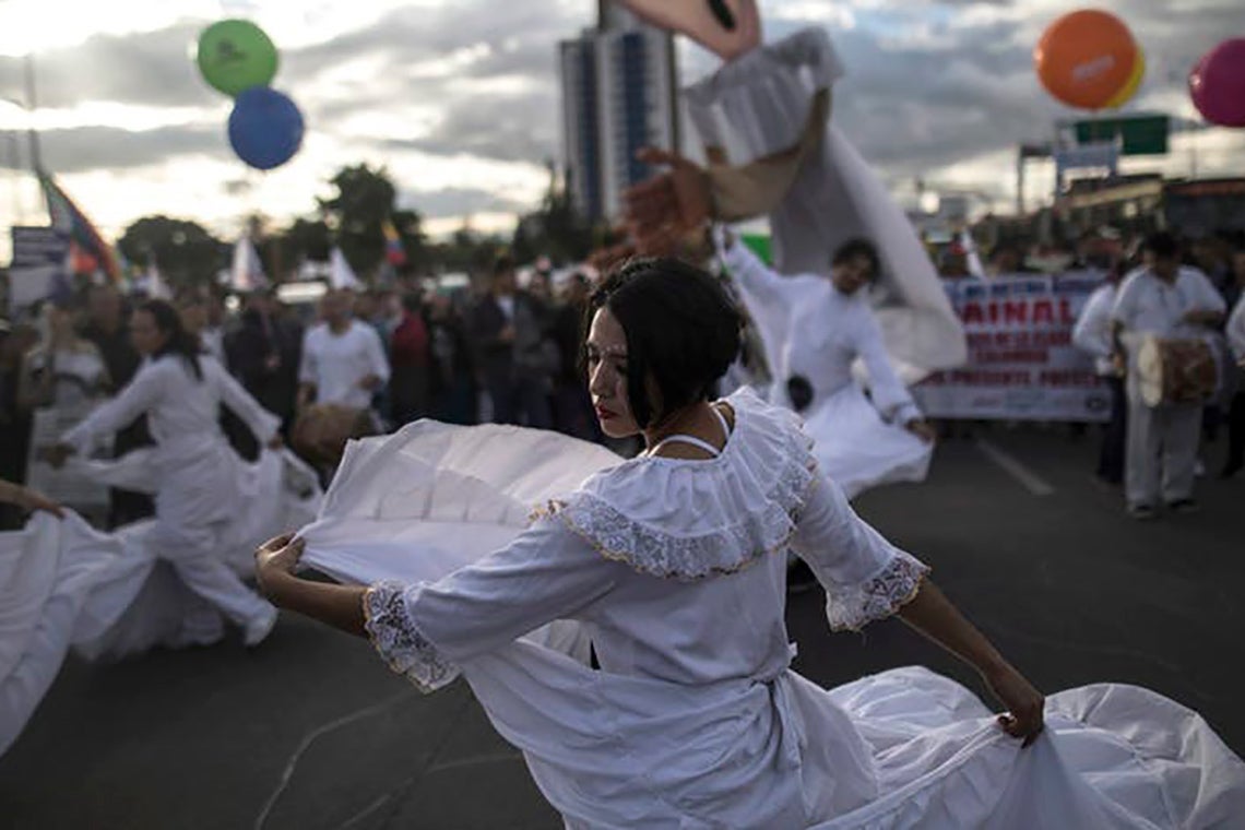 Photo of woman dancing during a protest march in Bogota