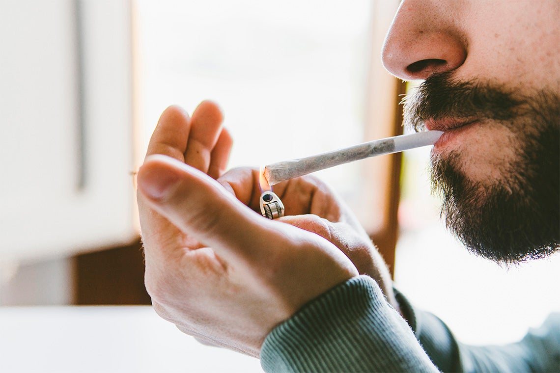 Man smoking cannabis in his home