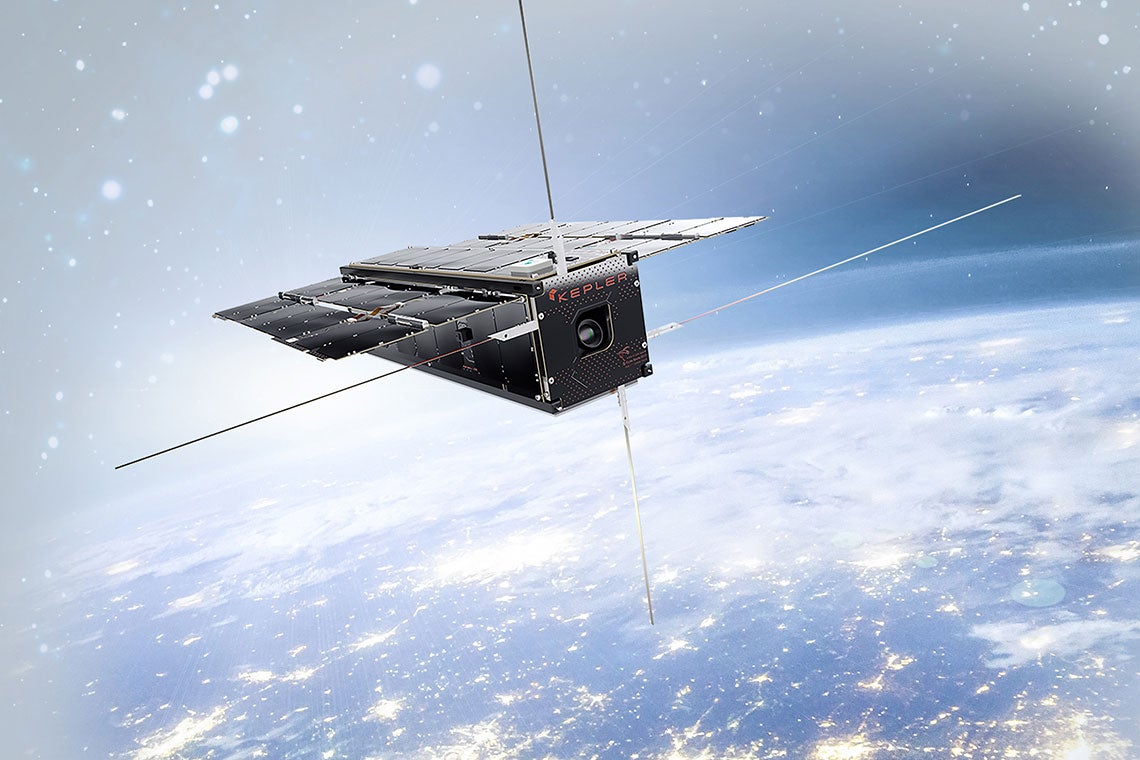 A Kepler Communications internet satellite floats above the nighttime Earth