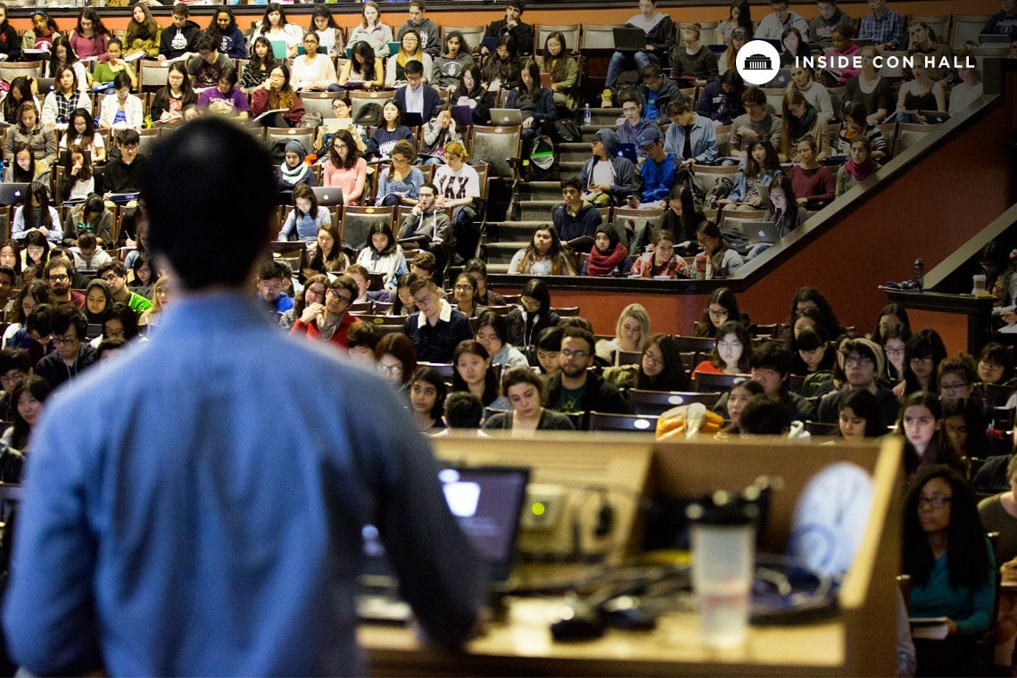 Photo of Yip at podium lecturing students at Con Hall