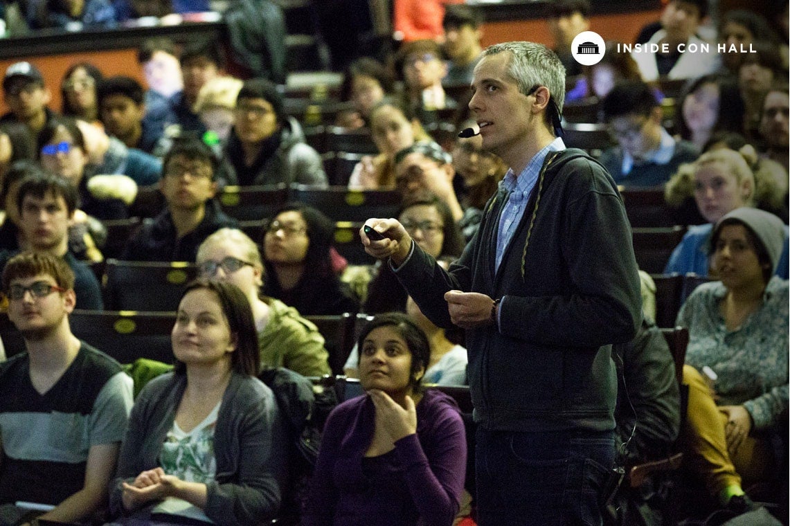 Photo of Reid standing among students lecturing at Con Hall