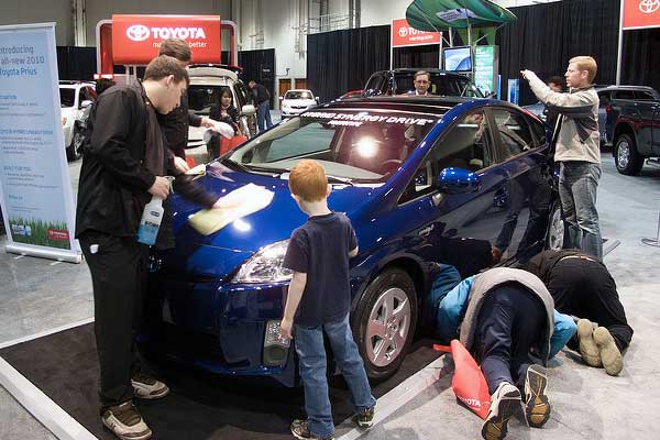 photo of people checking out a Prius car at auto show