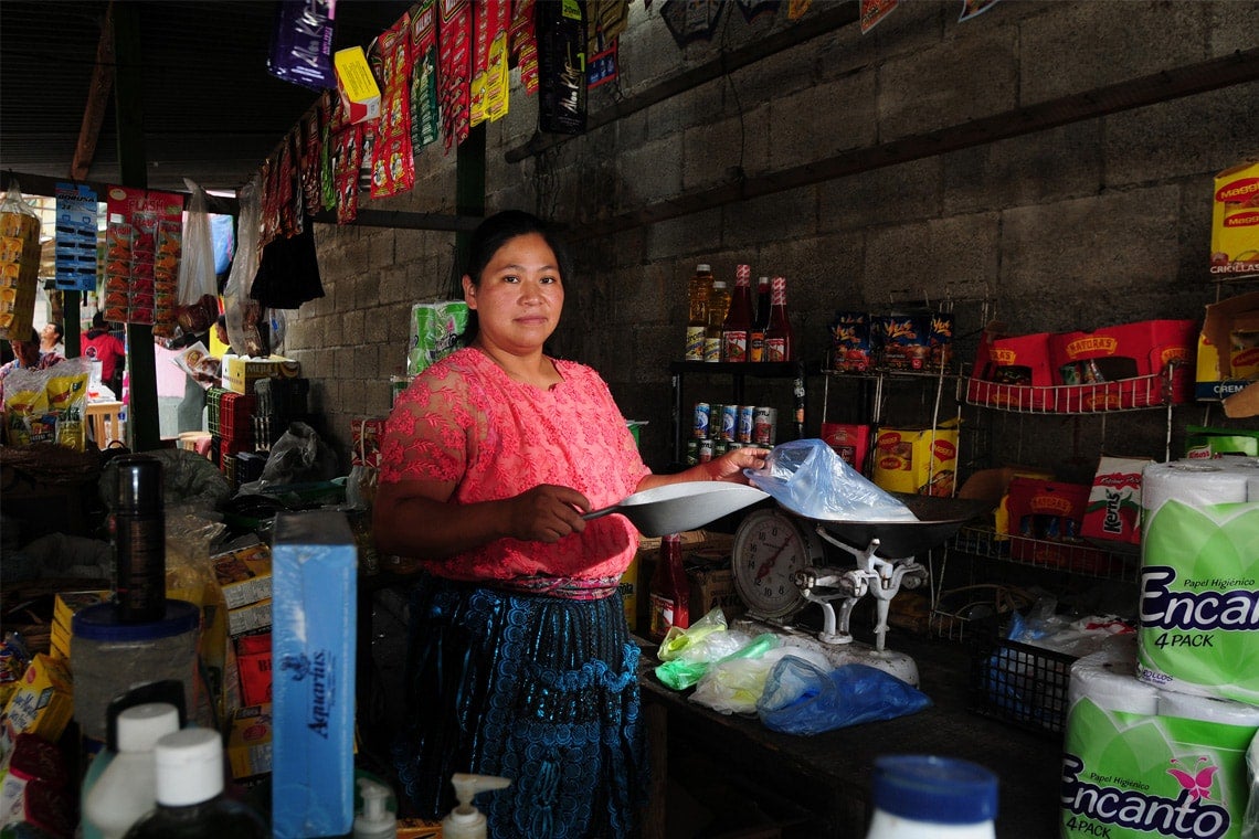 Photo of woman scooping out food at a produce market in Guatemala