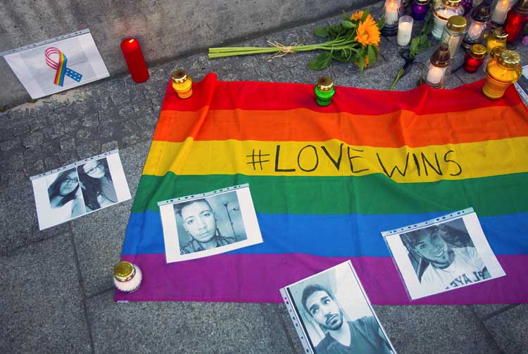 photo of pride flag, candles and flowers outside U.S. embassy in Warsaw