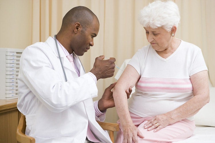Photo of doctor giving needle to patient
