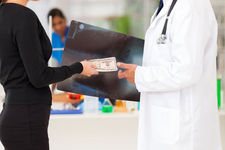 stock photo of doctor taking money from a patient