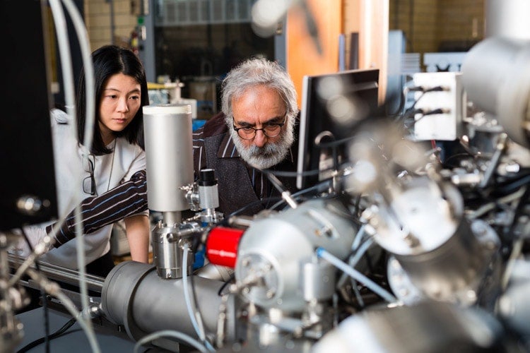 Student and professor examine a mass spectrometer