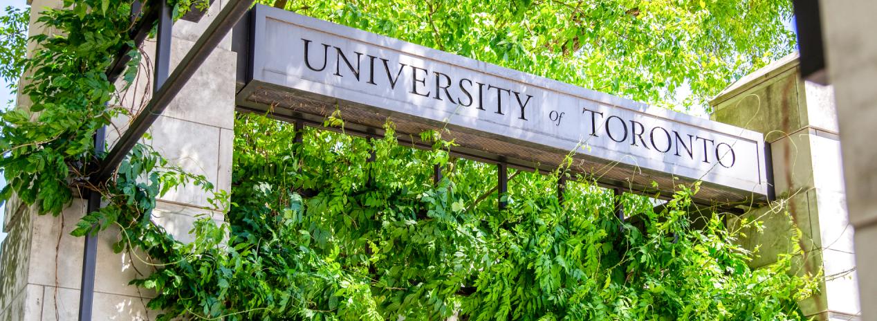 University of Toronto sign surrounded by lush green foliage