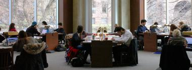 Students studying at tables inside a U of T library. 