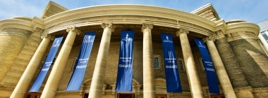 Exterior of Convocation Hall decorated with blue U of T banners.