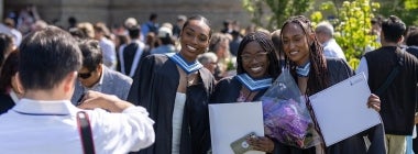 Graduating students smile for a photographer