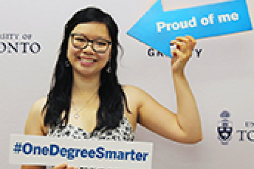 A woman with glasses holds up two signs