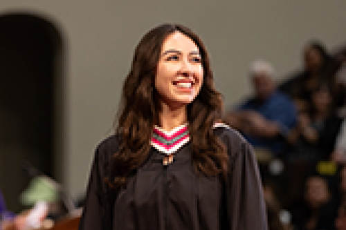 A grad smiles on stage