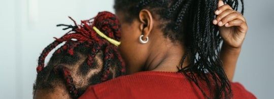 a Black mother holds her young daughter
