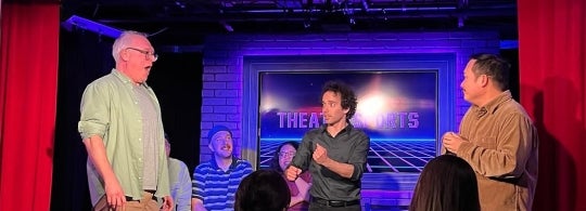 Robert-Tahiri on stage with a couple of volunteers