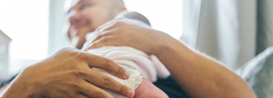 Father holding a newborn infant