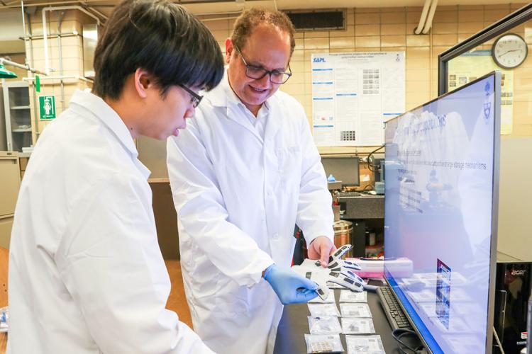 PhD candidate Yu-Chen (Gary) Sun and Professor Hani Naguib hold a glove made with smart materials in a laboratory