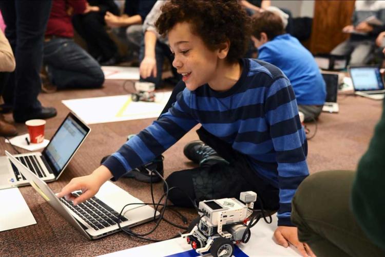 photo of kids playing and learning with laptops and robots
