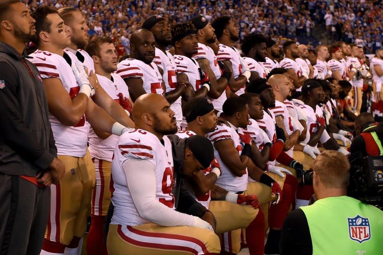 photo of football players taking a knee