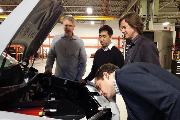 photo of researchers looking under the hood of car