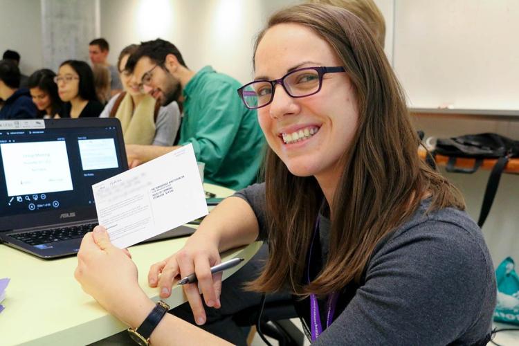 Photo of students signing postcards