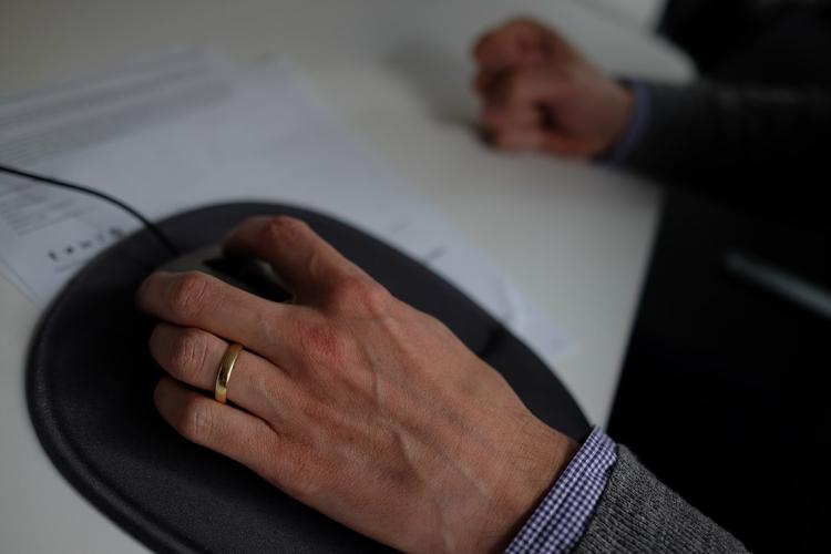 Hand with wedding ring in office