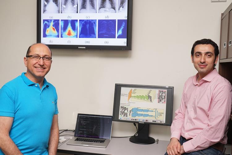 Photo of Shahrokh Valaee and Hojjat Salehinejad beside a computer