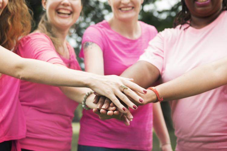 Photo of women in pink giving each other support