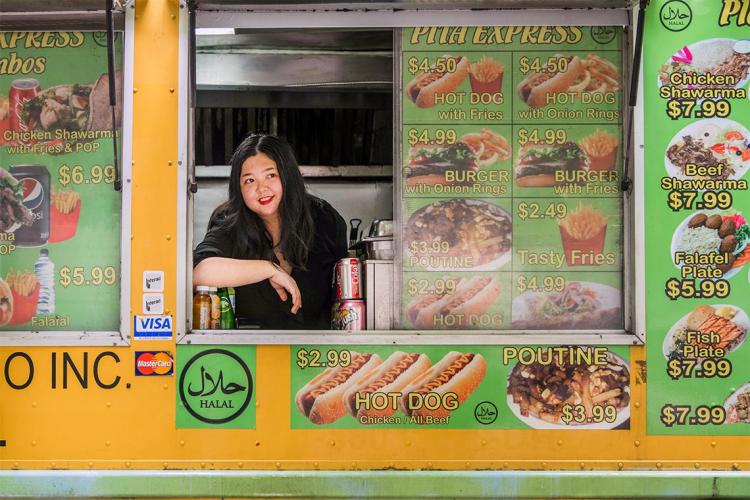 Joanna Luo posing for a portrait in a food truck window