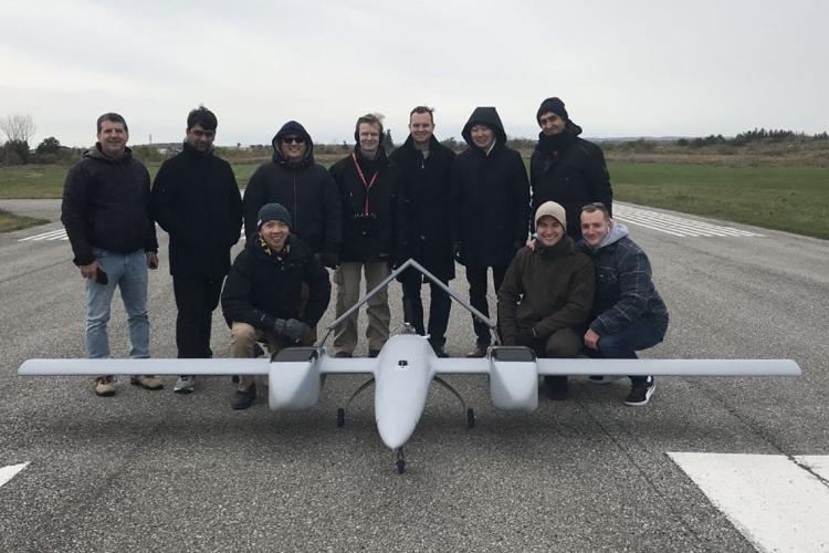 photo of the DX-3 Vanguard drone and the team behind it