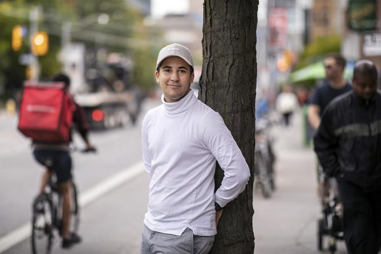 Portrait of Patrick Pallagi leaning on a pole outdoors