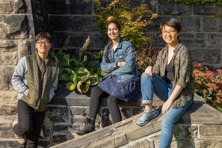 Chan-min Roh, Abnash Bassi and Shiqi Xu pose outside University College on a sunny fall day