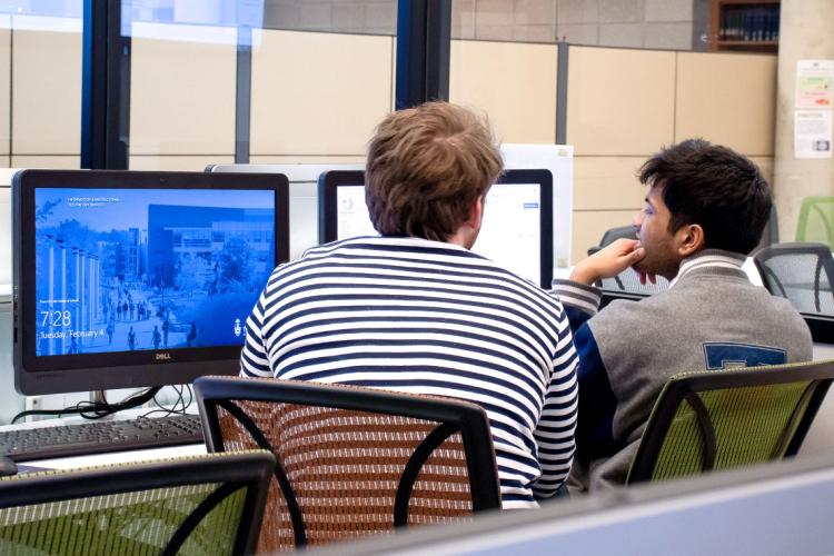 Two students at a computer terminal making edits to a Wikipedia page