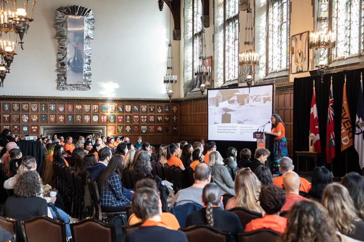 wide view of the Great Hall at Hart House showing the crowd listening to Brenda Wastasecoot speaking
