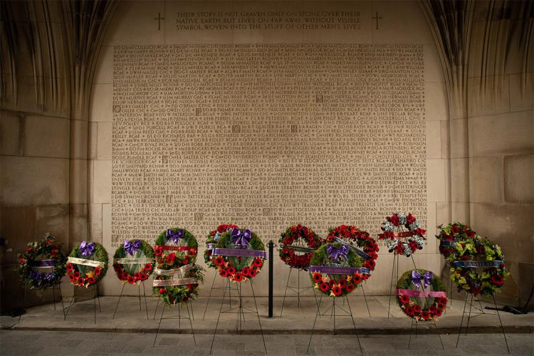 wreaths are laid in front of the memorial wall undernearth soldier's tower at the University of Toronto