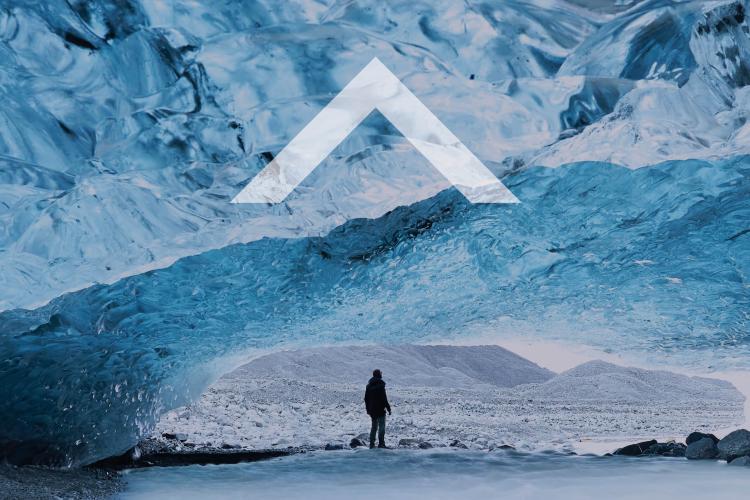 A person walking alone on a rocky, icy surface.