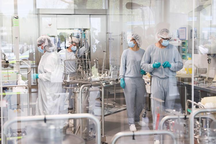 Scientists in a cleanroom manufacturing vaccines