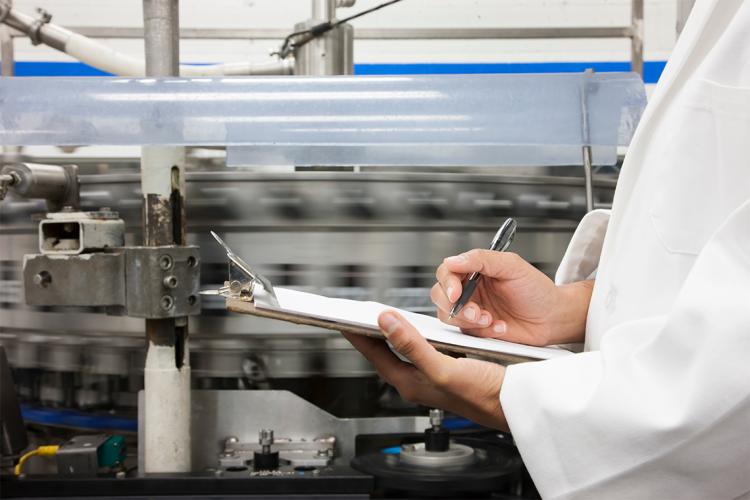 A person holding a clipboard in a lab.